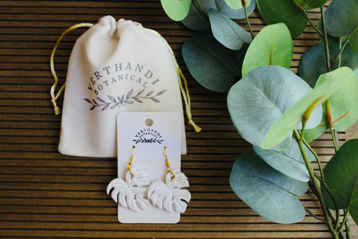 Monstera Dangle earrings, styled flat lay