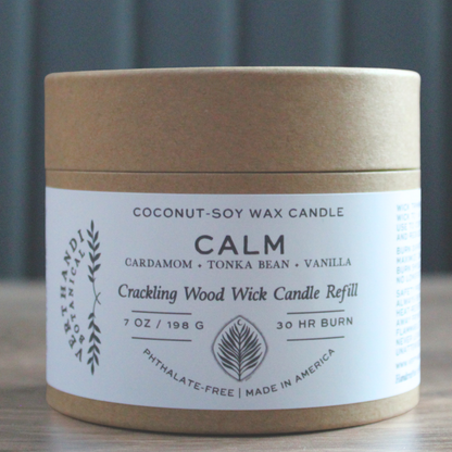 Coconut-soy wax candle refill container with label on a wooden surface