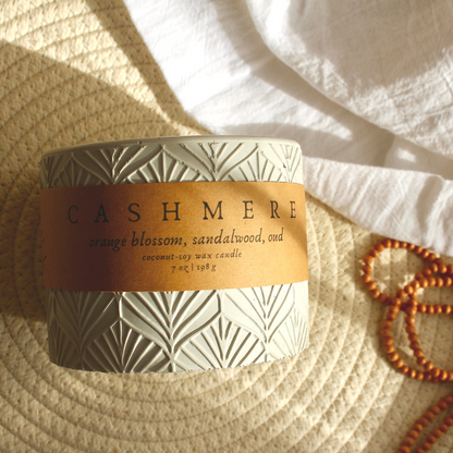 A concrete jar candle with a label that reads &