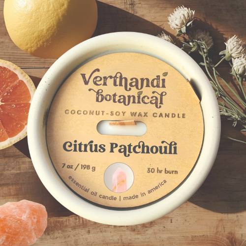 citrus patchouli essential oil candle with coconut soy wax, a crackling wood wick in a concrete jar with a crystal embed, top view of dust cover