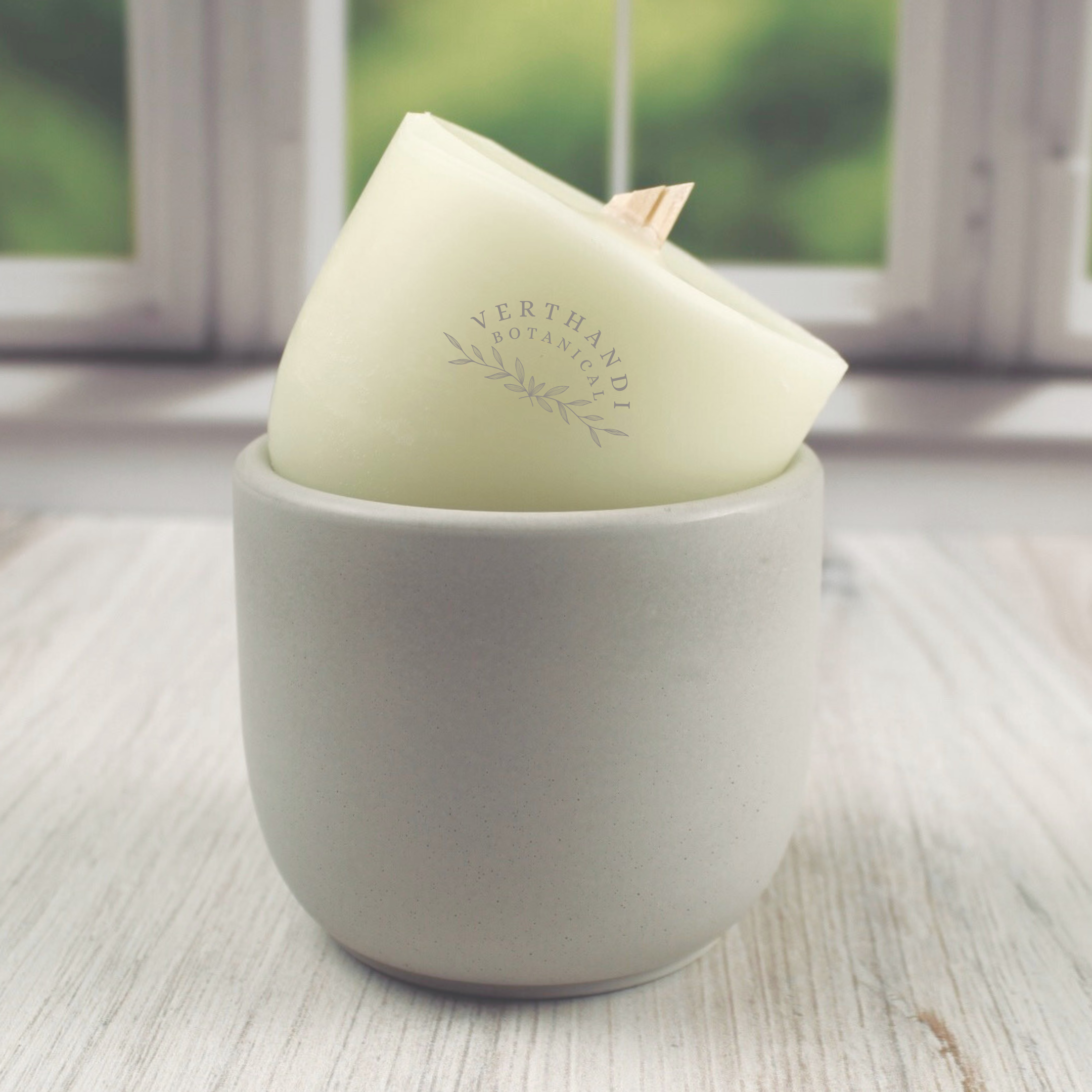 coconut soy wax candle refill with crackling wood wick propped up by an empty concrete candle jar