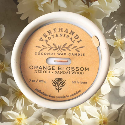 orange blossom scented candle with coconut soy wax and crackling wood wick in cement jar, top view dust cover