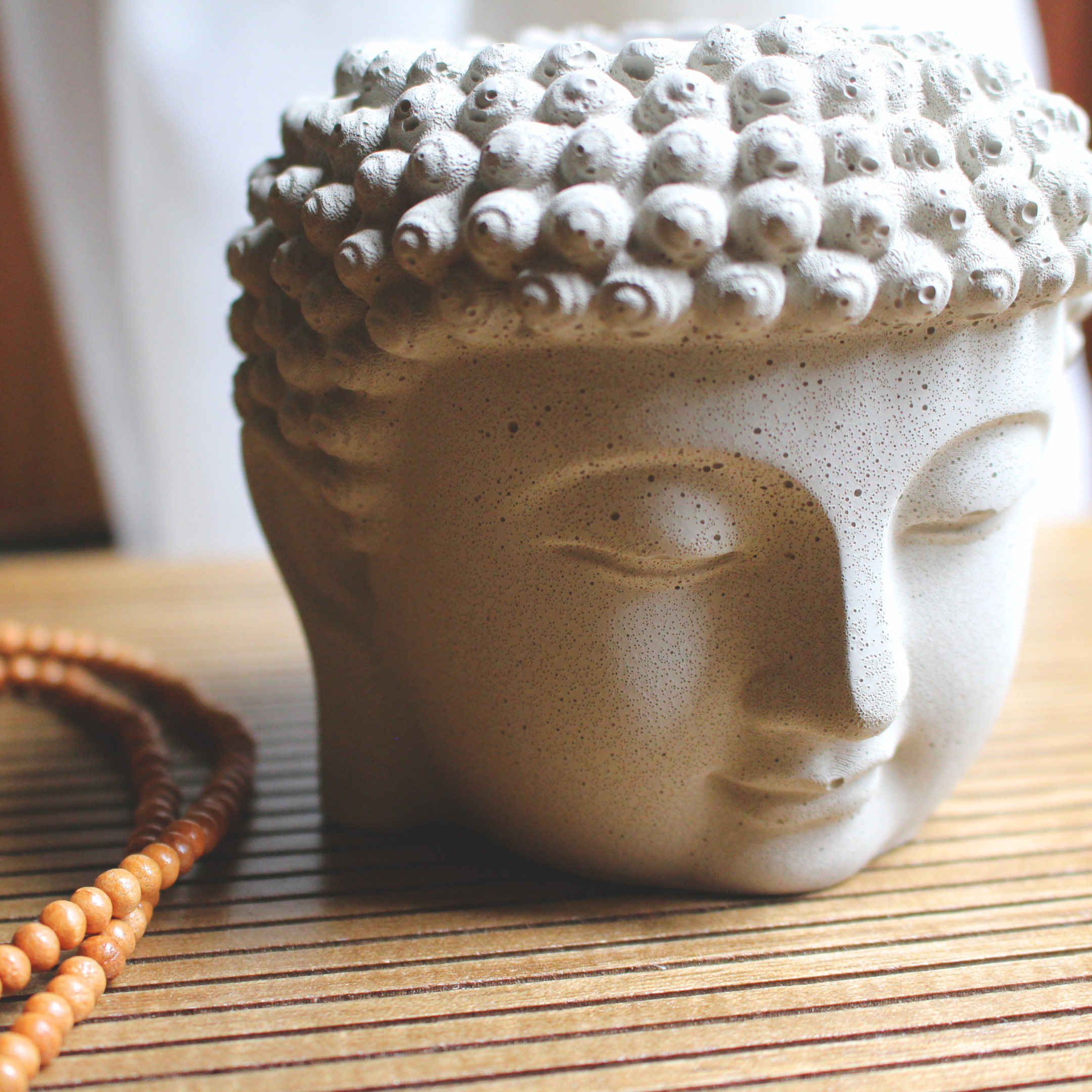 tranquility buddha head coconut soy candle with crackling wood wick in buddha head concrete jar, front  view